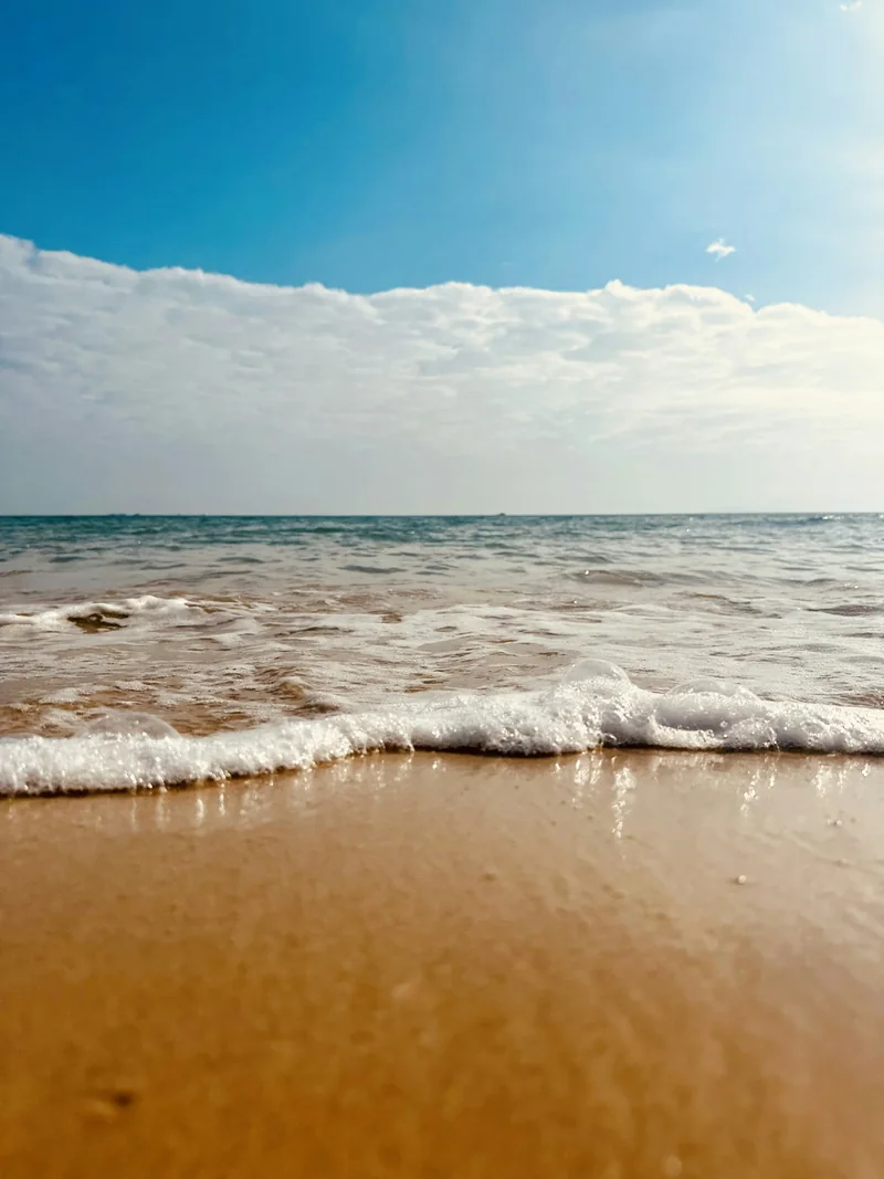 Waves moving onto a sandy shoreline in Lingshui